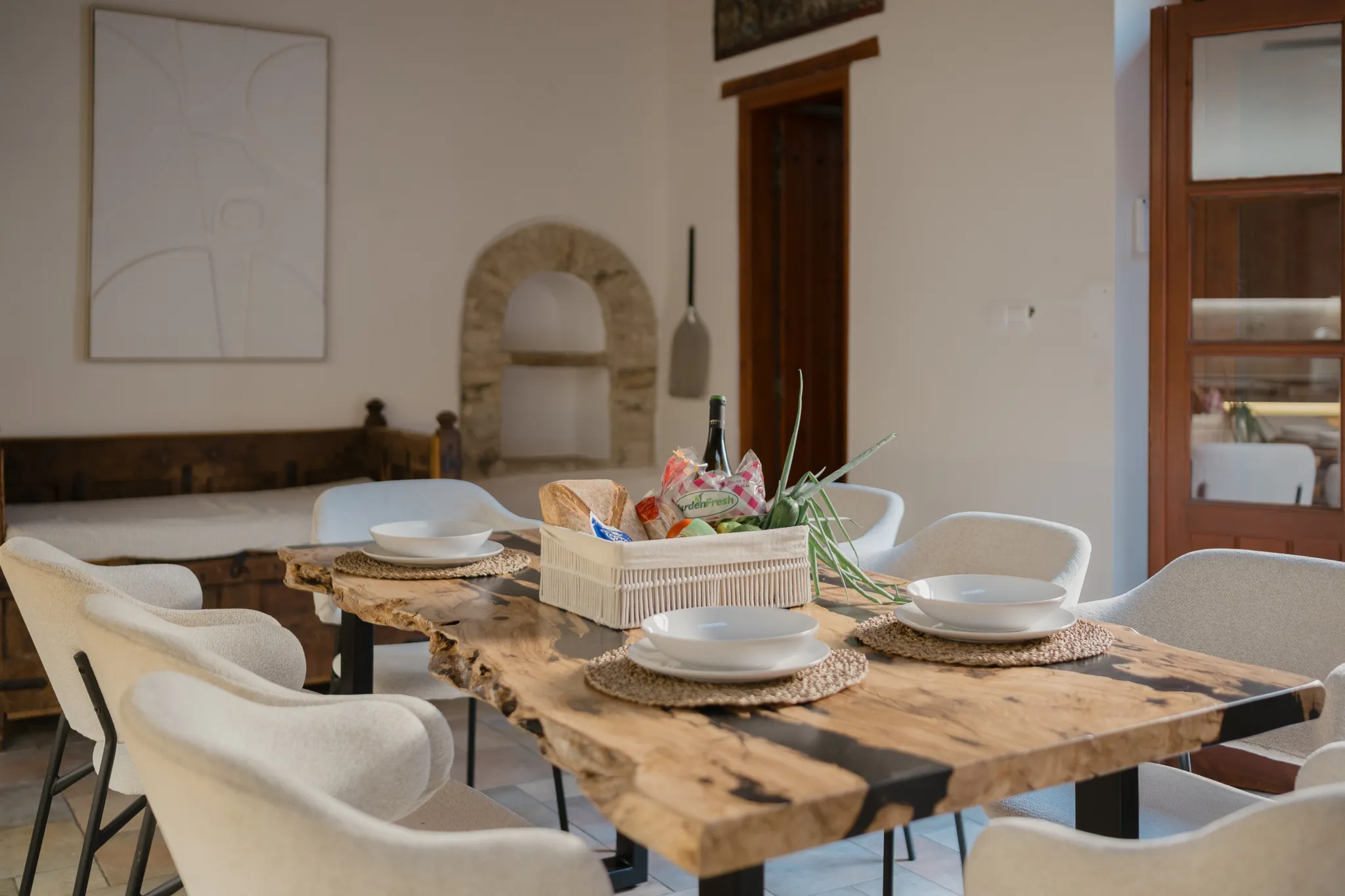 The olive-wood dining table with a welcome basket