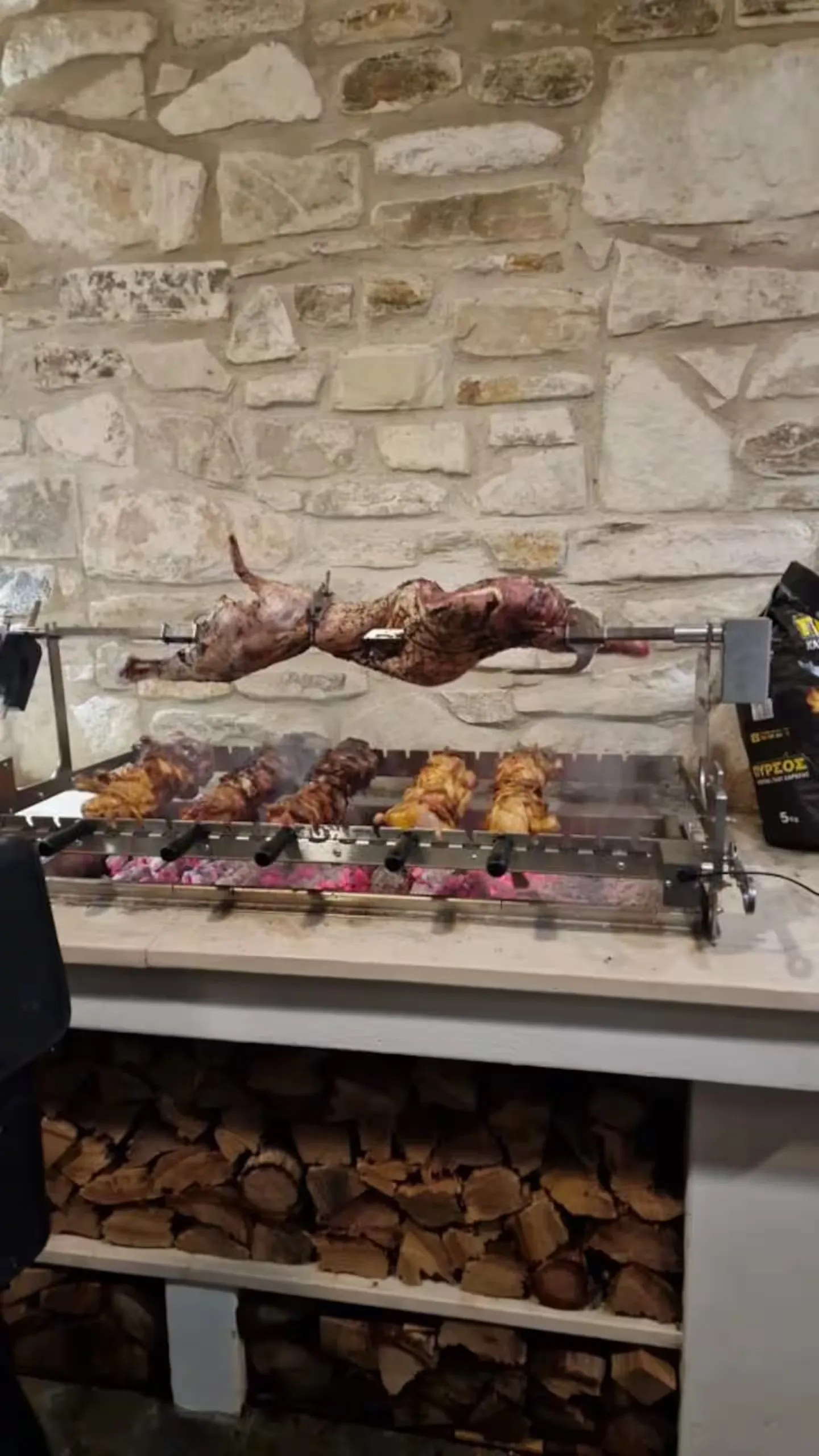 The motorised foukou spit-roasting over charcoal