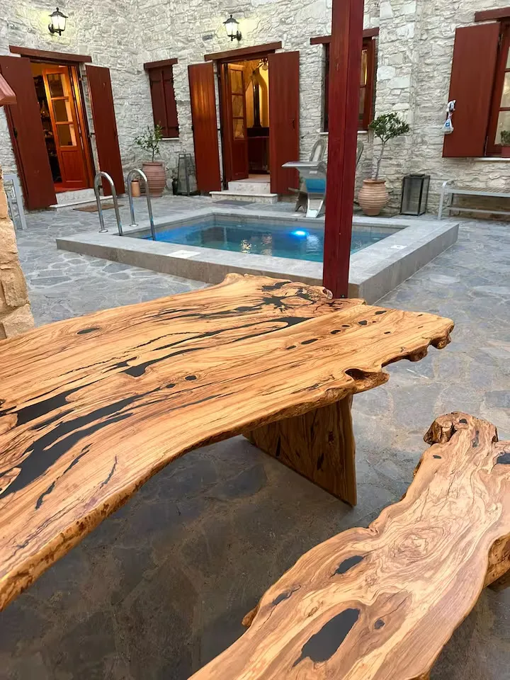 The olive-wood table beside the plunge pool