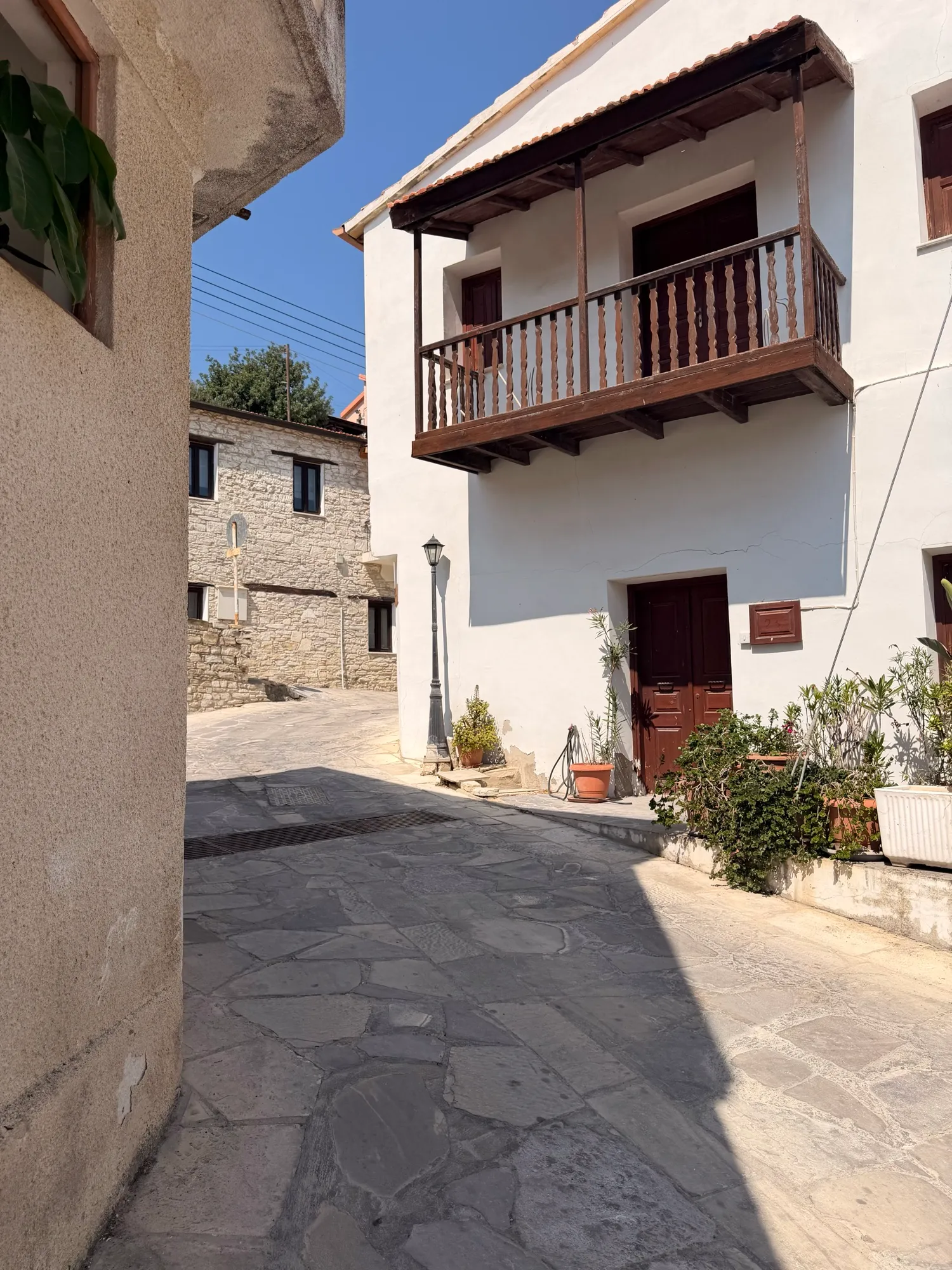 A whitewashed house with a carved wooden balcony
